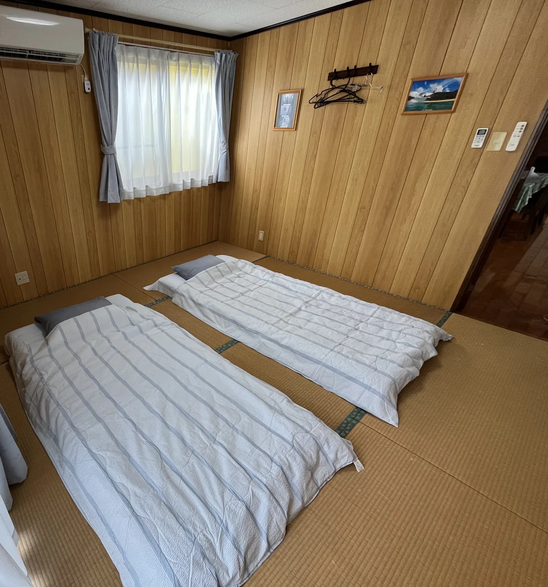 民宿あまんのもう一つの和室。木の壁の部屋に布団が2組